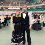 武道館での第15回ブラインドダンス選手権大会に於いて、ペアの男性と一緒に、記念撮影をする小西さん。黒いドレスで裾には白色のフリルが付いています。